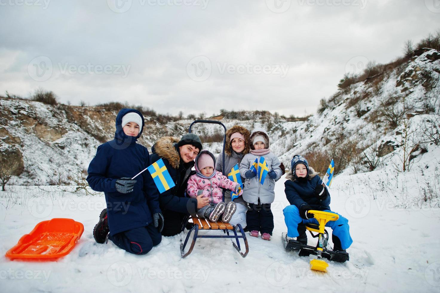 familia escandinava con bandera de suecia en el paisaje sueco de invierno. foto