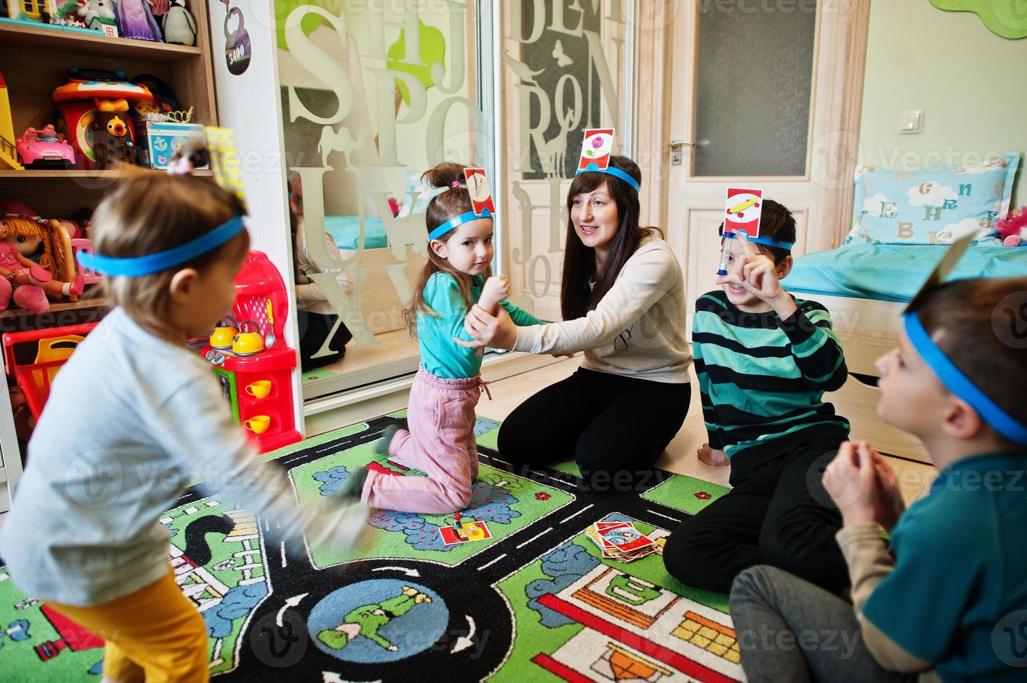 familia feliz con cuatro niños jugando adivina quién mientras se divierte en casa. foto