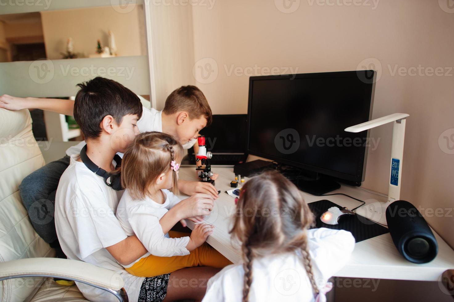 Kids using microscope learning science class at home. photo