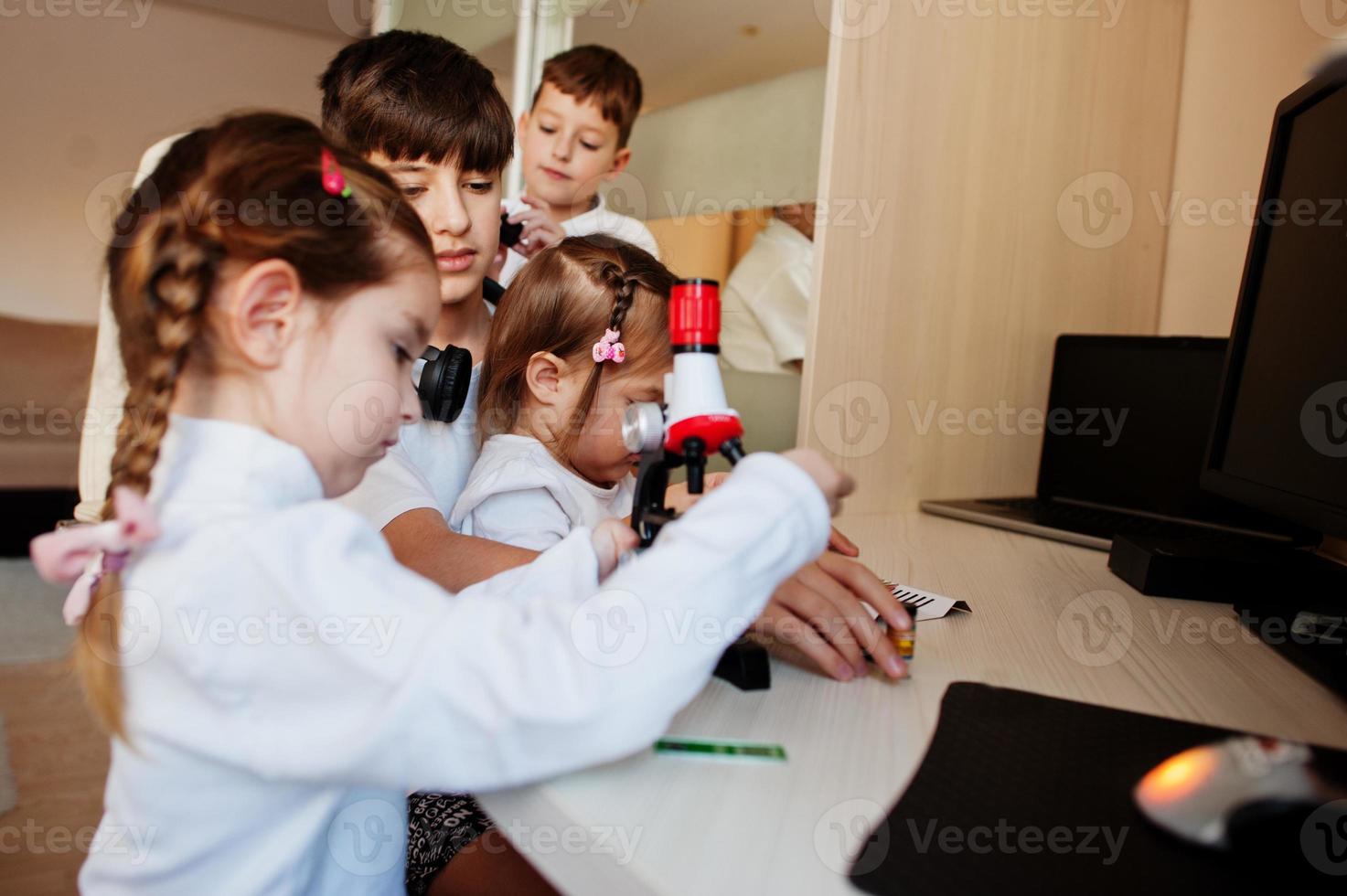 Kids using microscope learning science class at home. photo