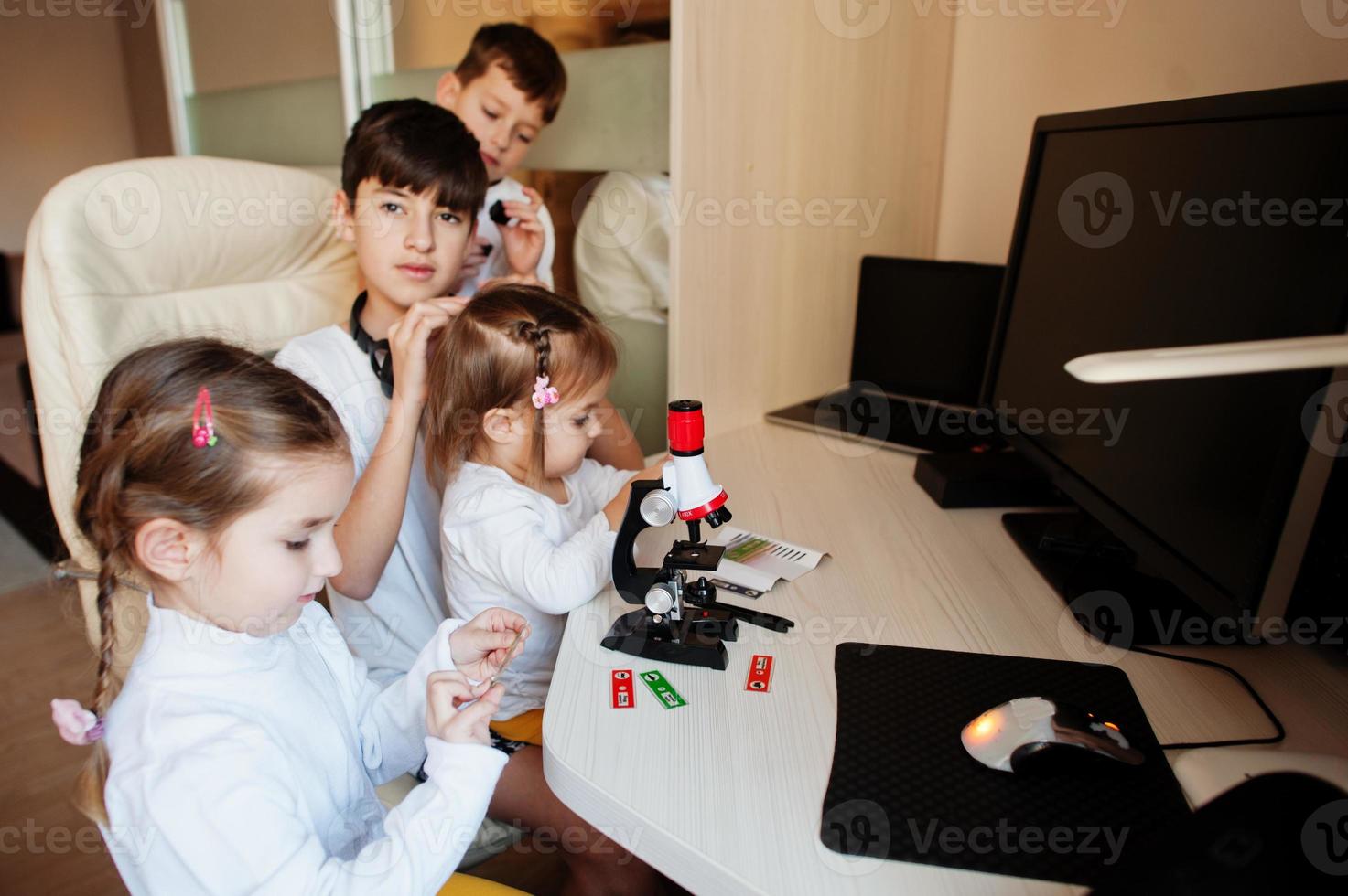 Kids using microscope learning science class at home. photo