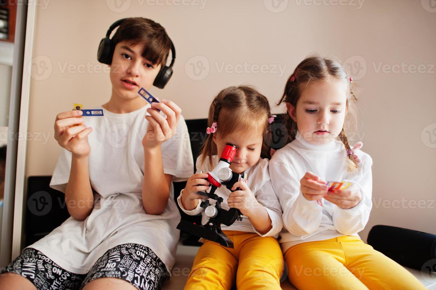 Kids using microscope learning science class at home. photo