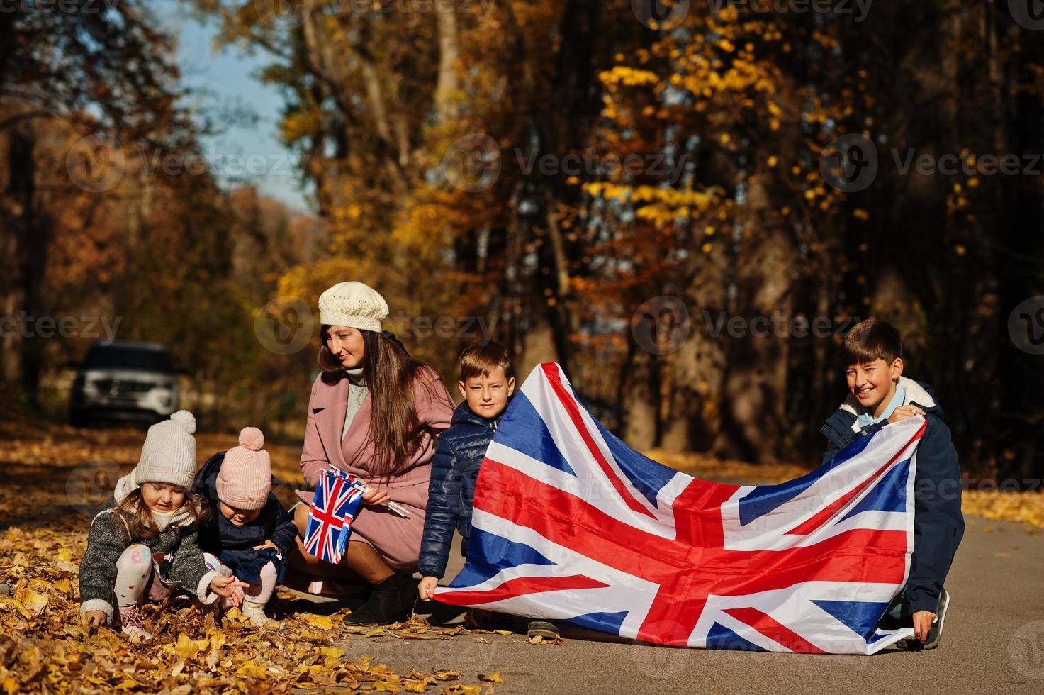 fiesta nacional del reino unido. familia con banderas británicas en el parque de otoño. britanicidad celebrando el Reino Unido. madre con cuatro hijos. foto