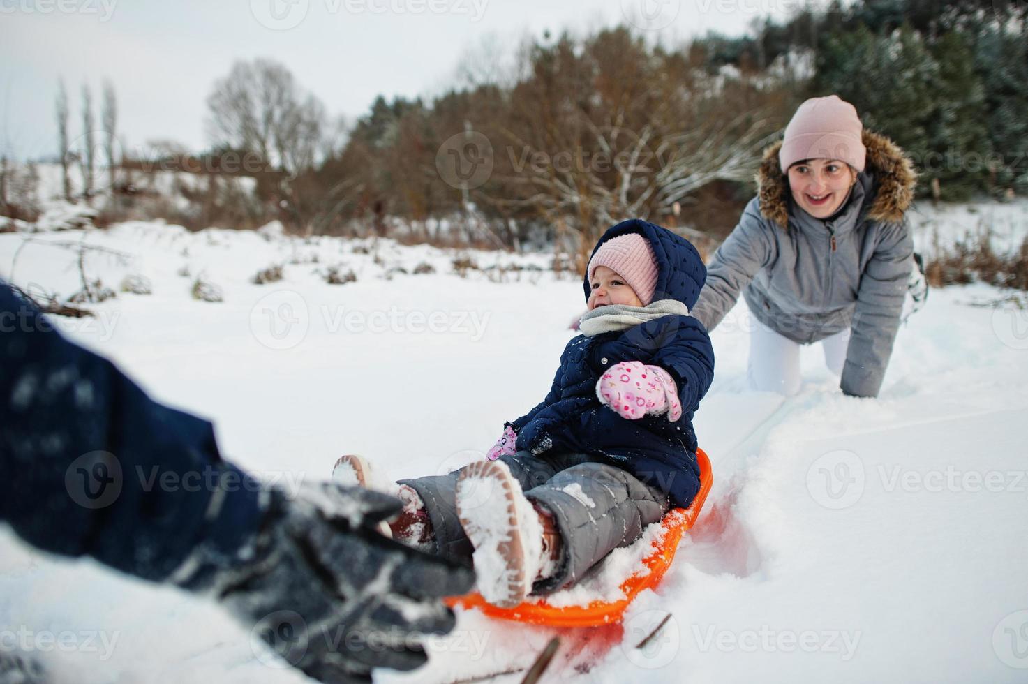 Mother playing with children in winter nature. Outdoors in snow. photo