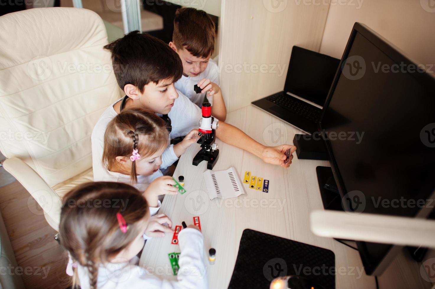 Kids using microscope learning science class at home. photo