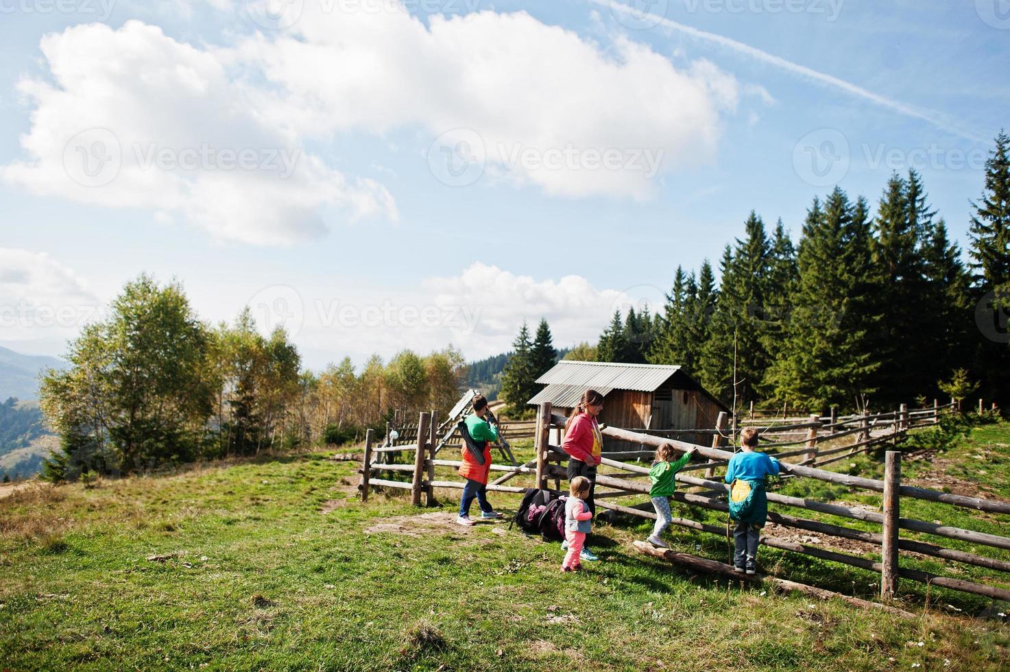 Family on a trekking day in the mountains. Ancient wooden cheese factory on top. photo