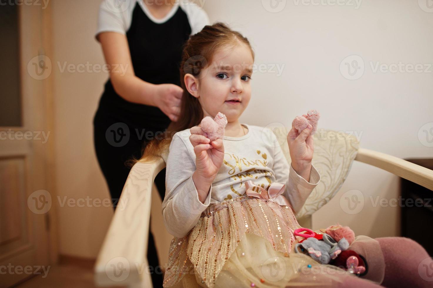 mamá haciendo peinado, niña con horquillas. foto