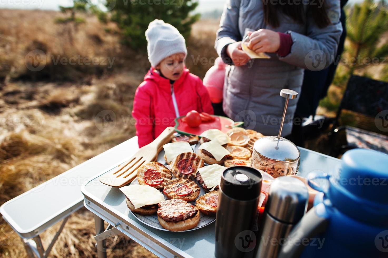 Family barbecuing on a deck in the pine forest. Bbq day with grill. photo