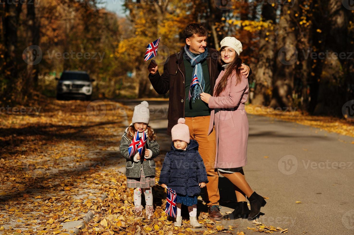 National holiday of United Kingdom. Family with british flags in autumn park.  Britishness celebrating UK. Two kids. photo