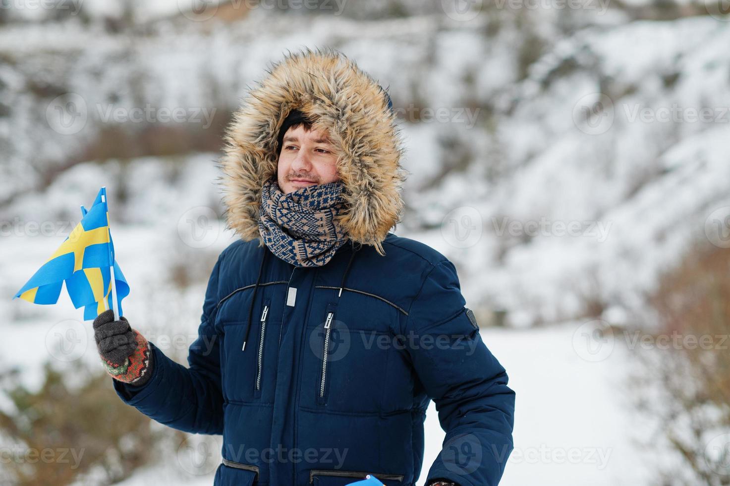 Scandinavian man with Sweden flag in winter swedish landscape. photo