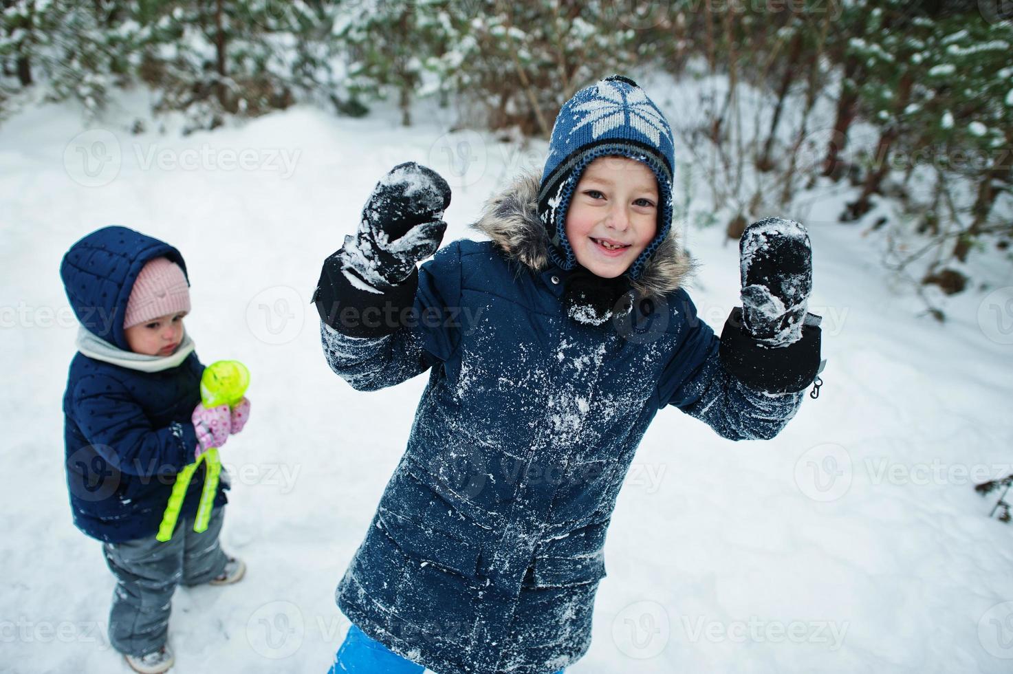 Boy and girl in winter nature. Outdoors in snow. photo