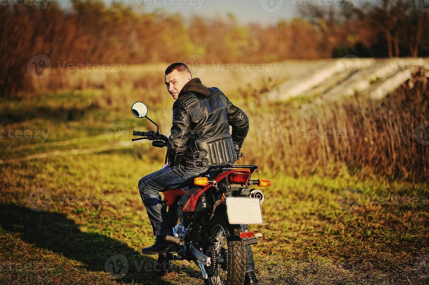 Enduro racer sitting on his motorcycle photo