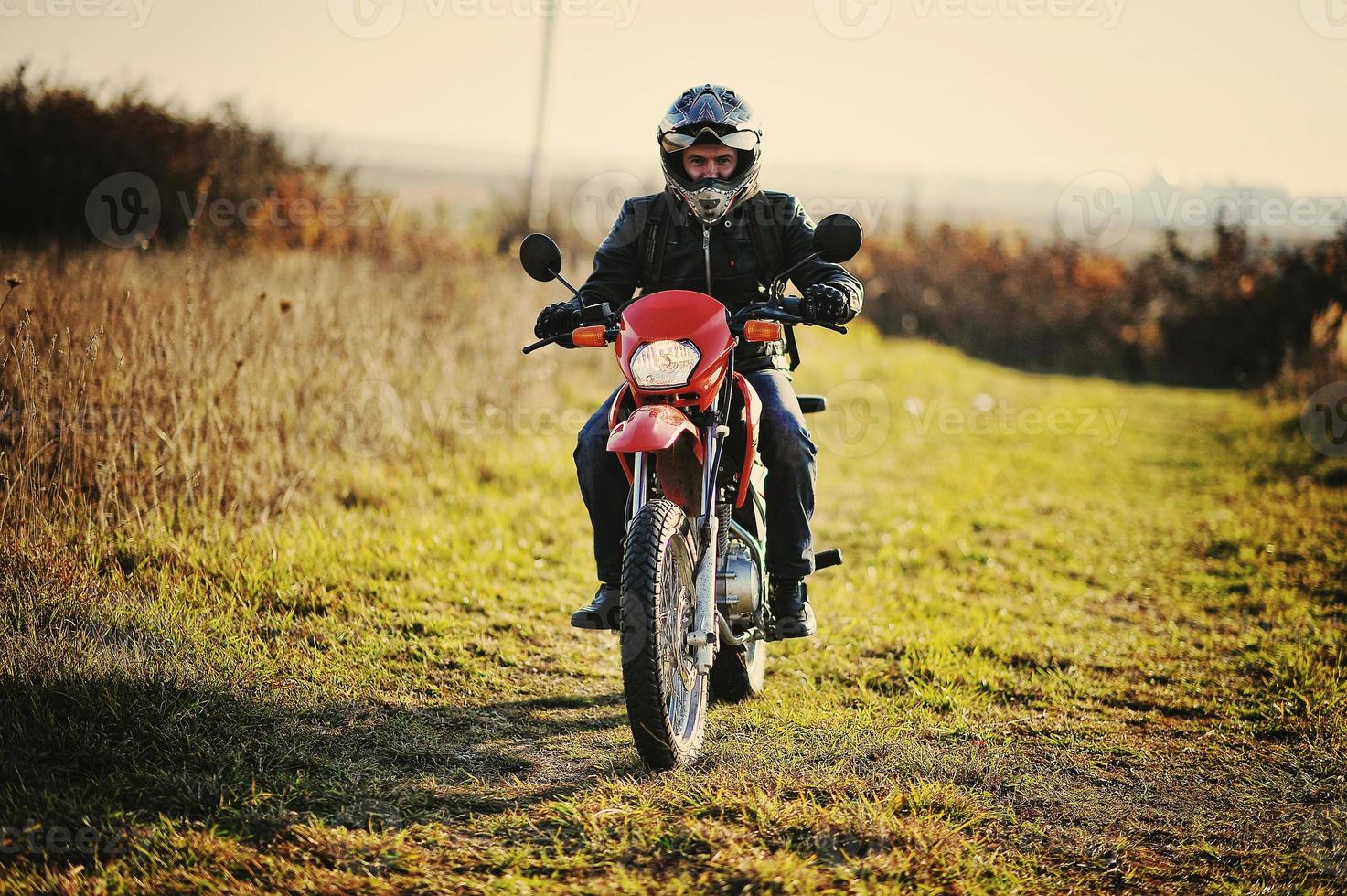 Enduro racer sitting on his motorcycle photo