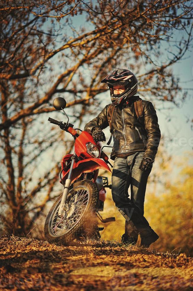 Motorcycle rider stay at sunset with him enduro bike photo