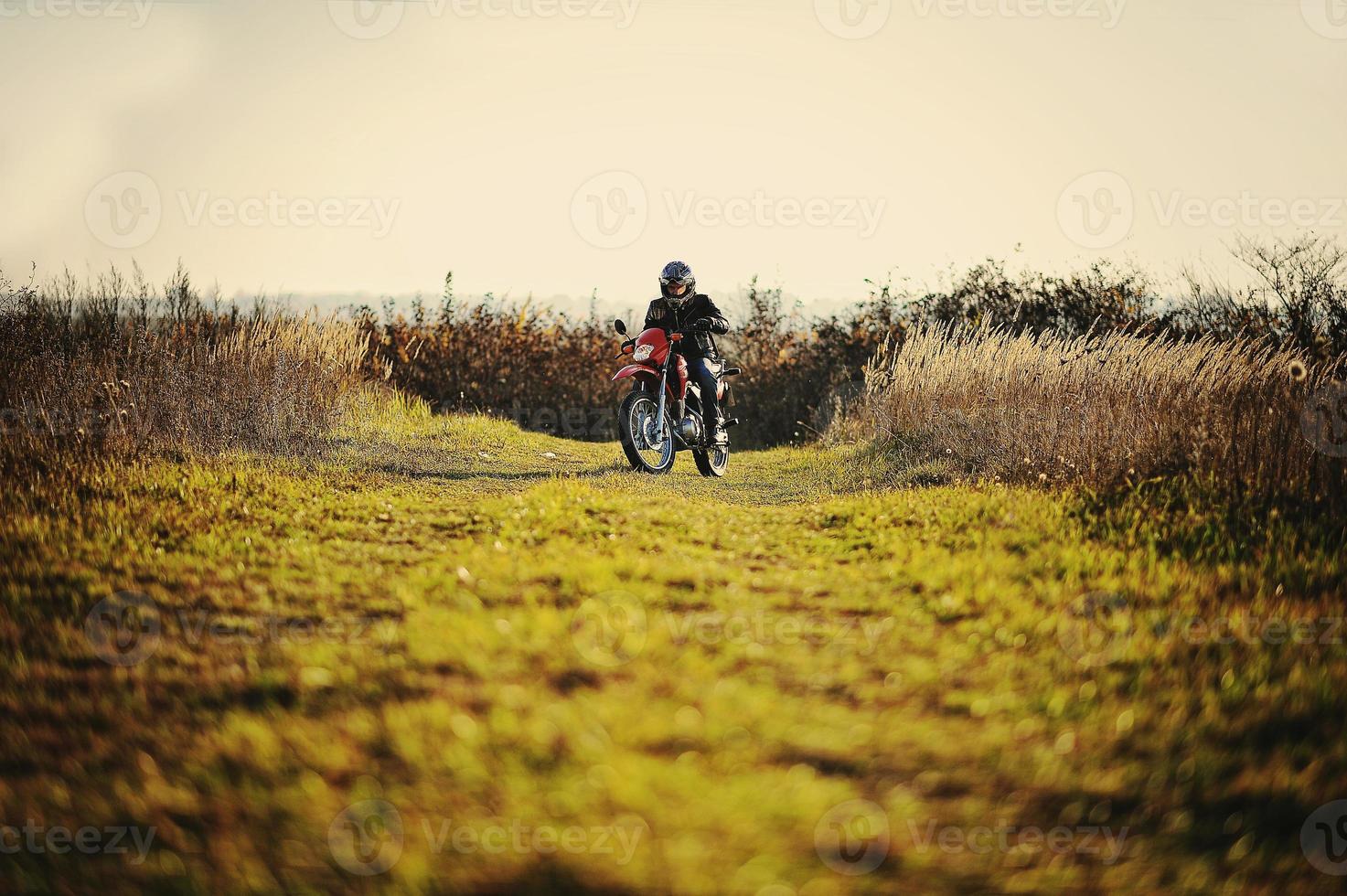 Enduro racer sitting on his motorcycle photo