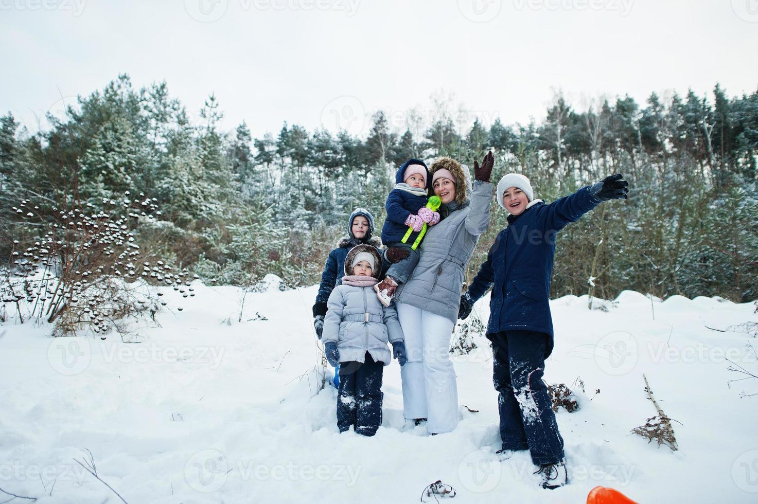 madre con cuatro hijos en la naturaleza invernal. al aire libre en la nieve. foto