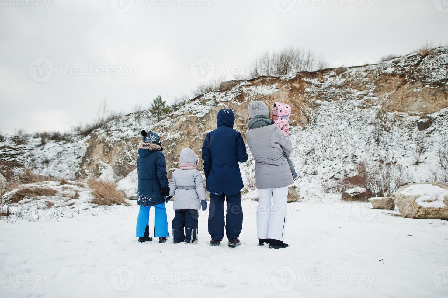 Back of family in winter outdoor, mother and four children. photo