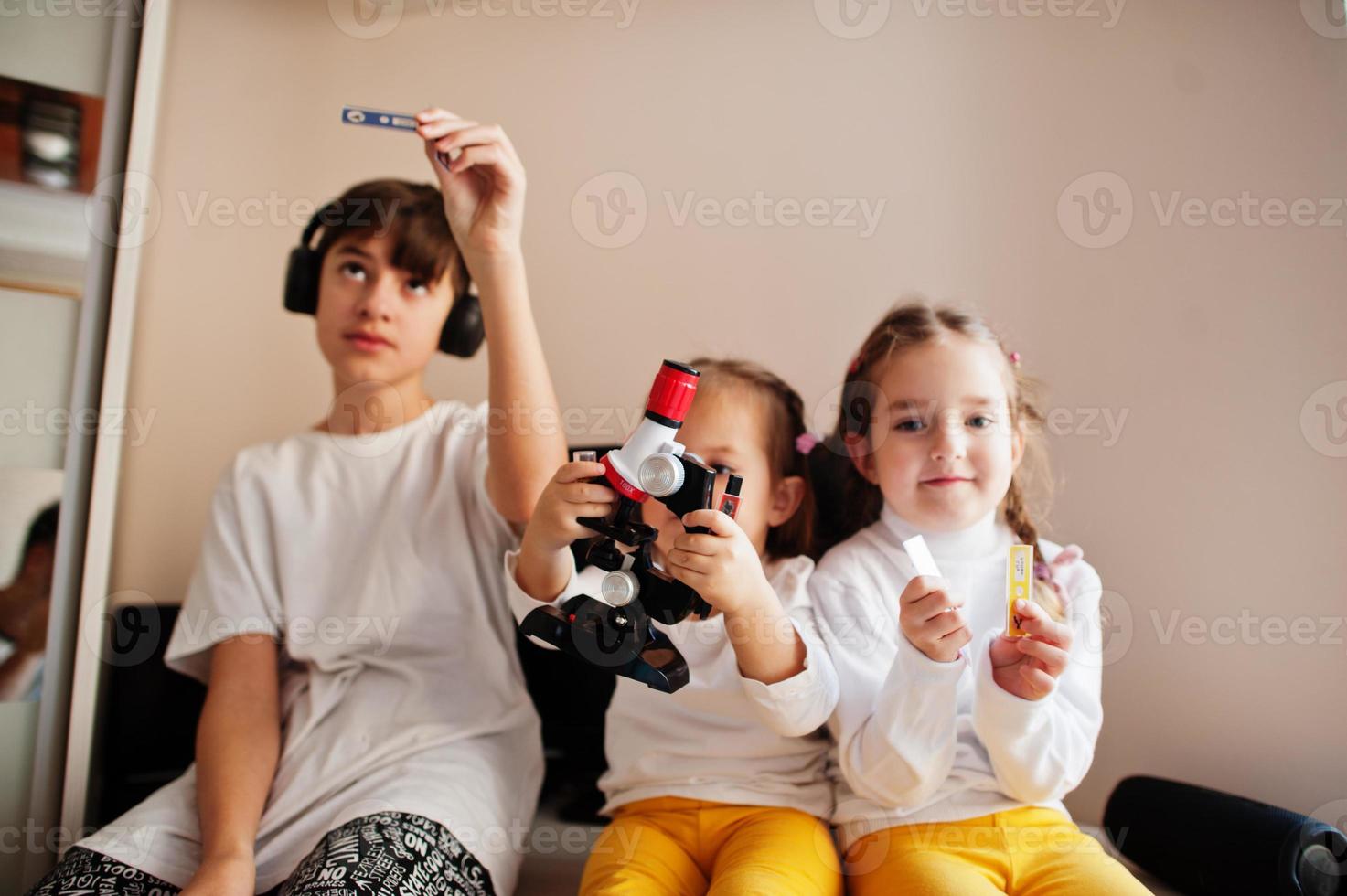 Kids using microscope learning science class at home. photo