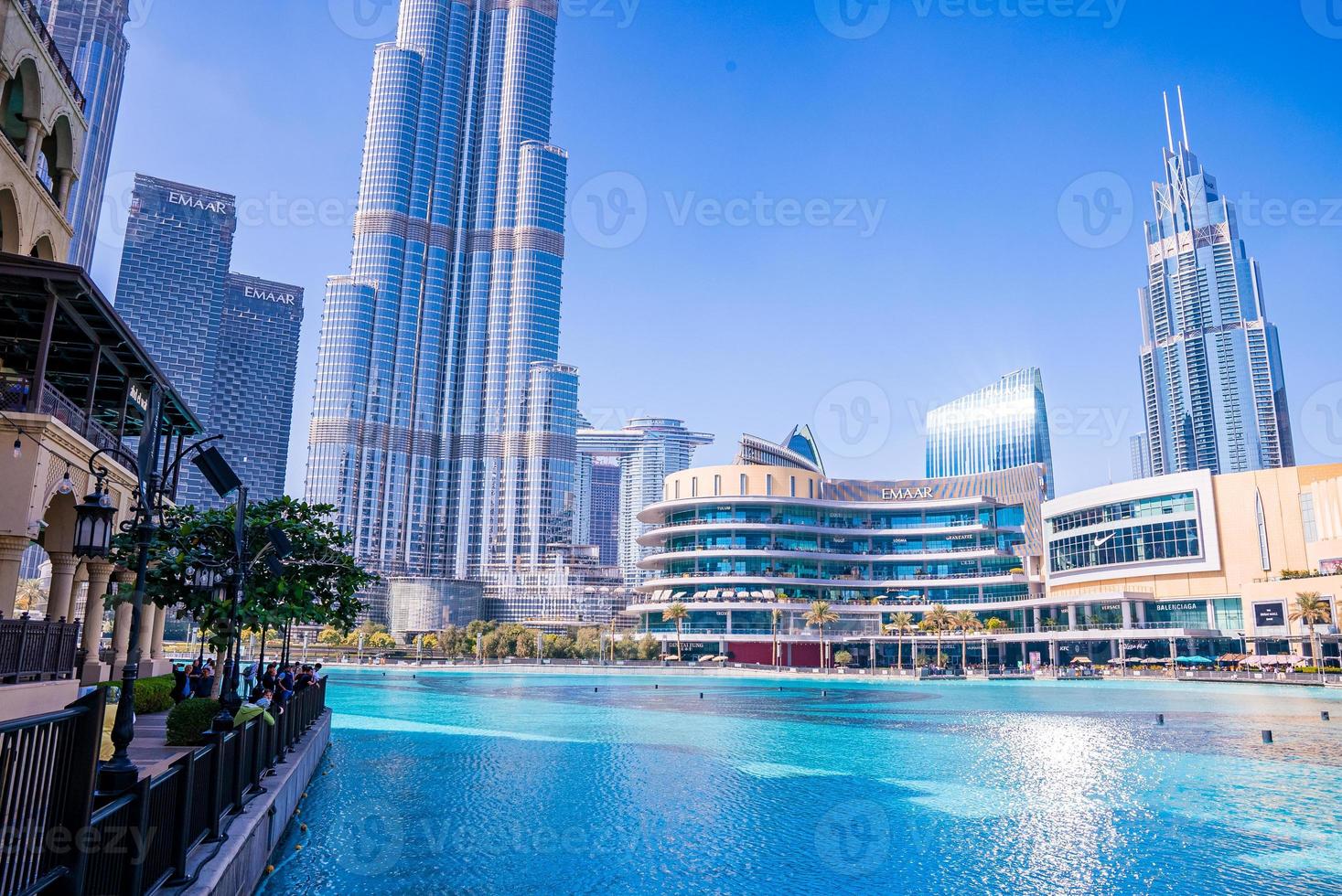 View of Burj Khalifa on a beautiful day with sun reflection by the fountains. photo