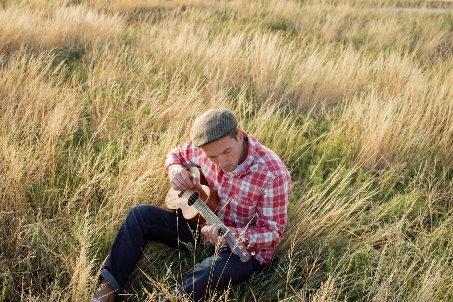 yong man play on ukulele outdoors photo