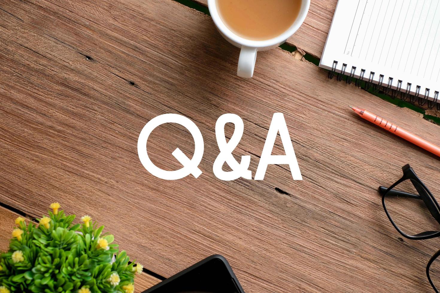 Q and A text over wooden table, business concept photo