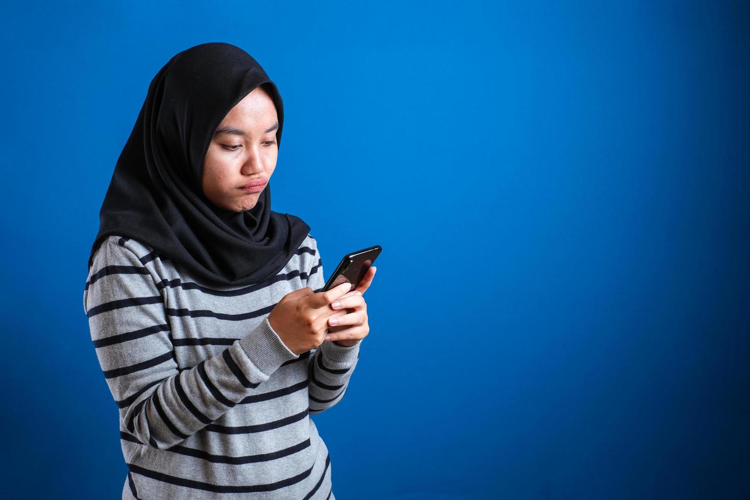 retrato de una linda y hermosa adolescente musulmana asiática que usa hiyab llorando triste cuando recibe malas noticias por teléfono foto