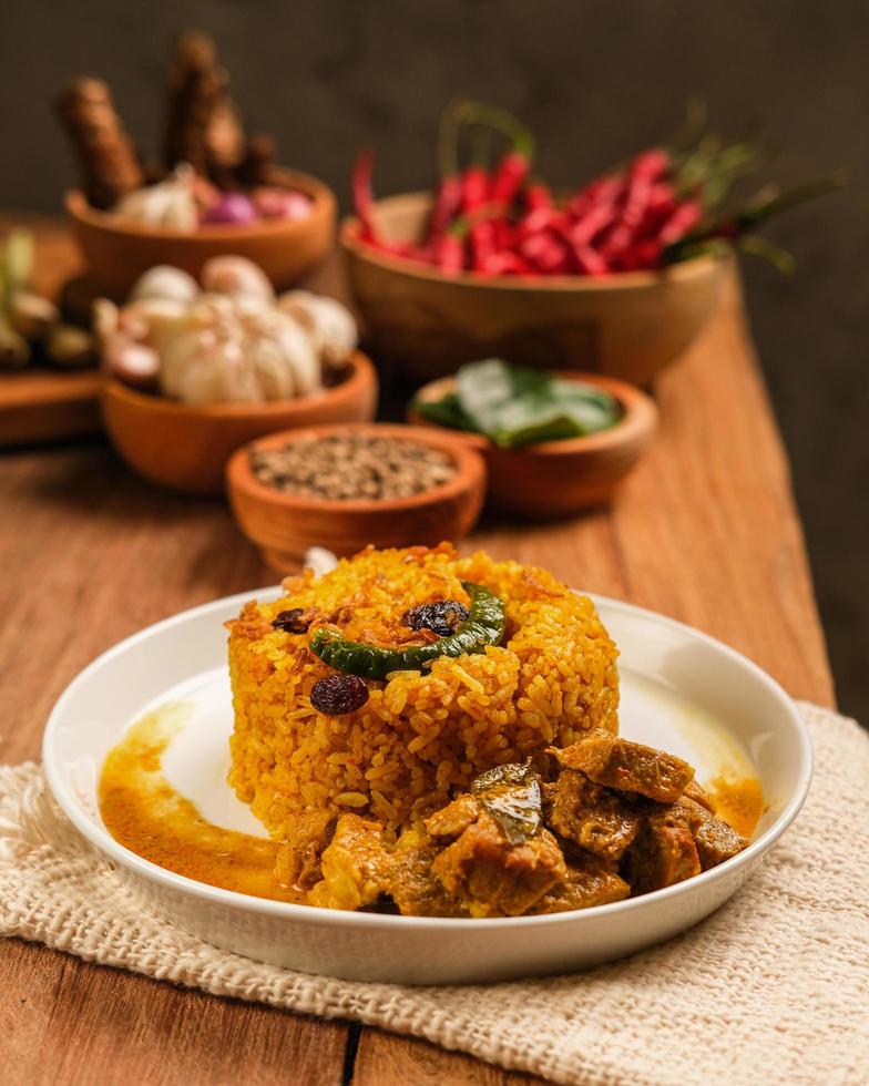 Delicious Indian Mutton Biryani Dish served on wooden table. photo