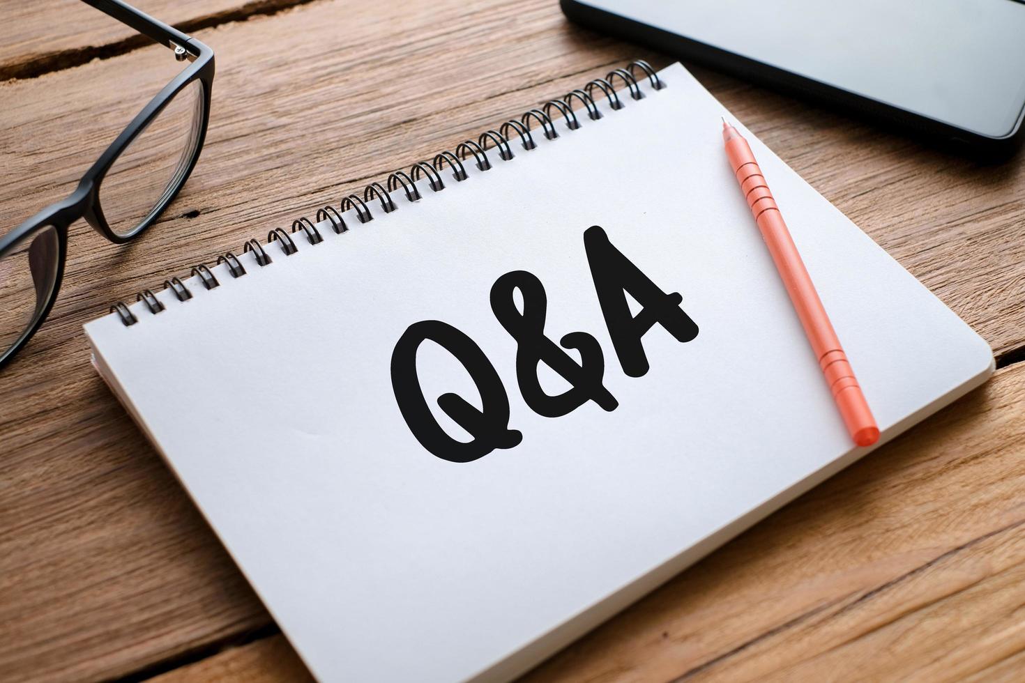 Q and A text over wooden table, business concept photo