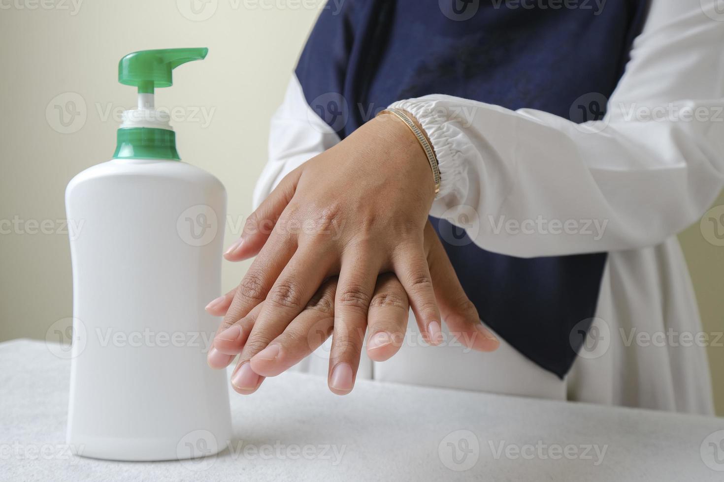 Washing hands by alcohol sanitizers or alcohol gel from pump bottle
