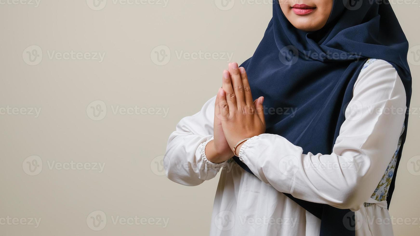 Asian Muslim women wearing hijab gesturing to welcome guests photo