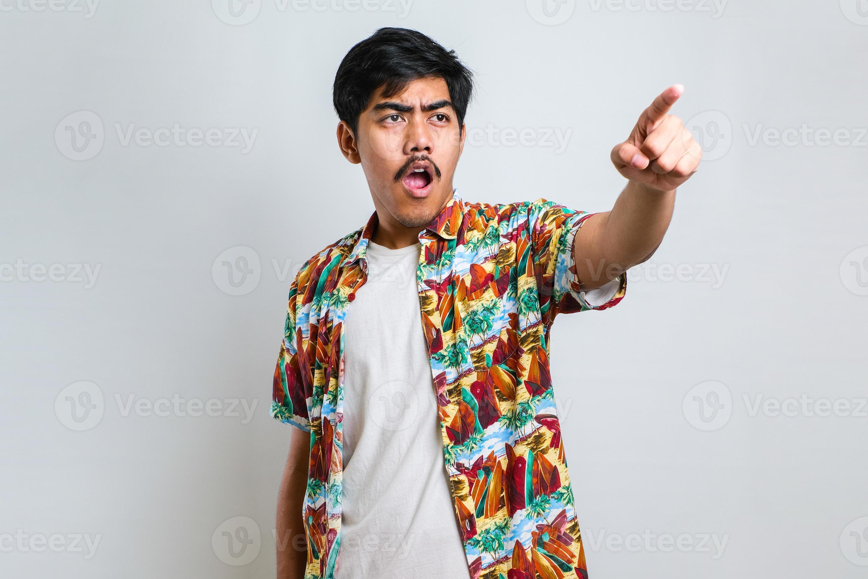 Asian man pointing with finger surprised ahead, open mouth amazed