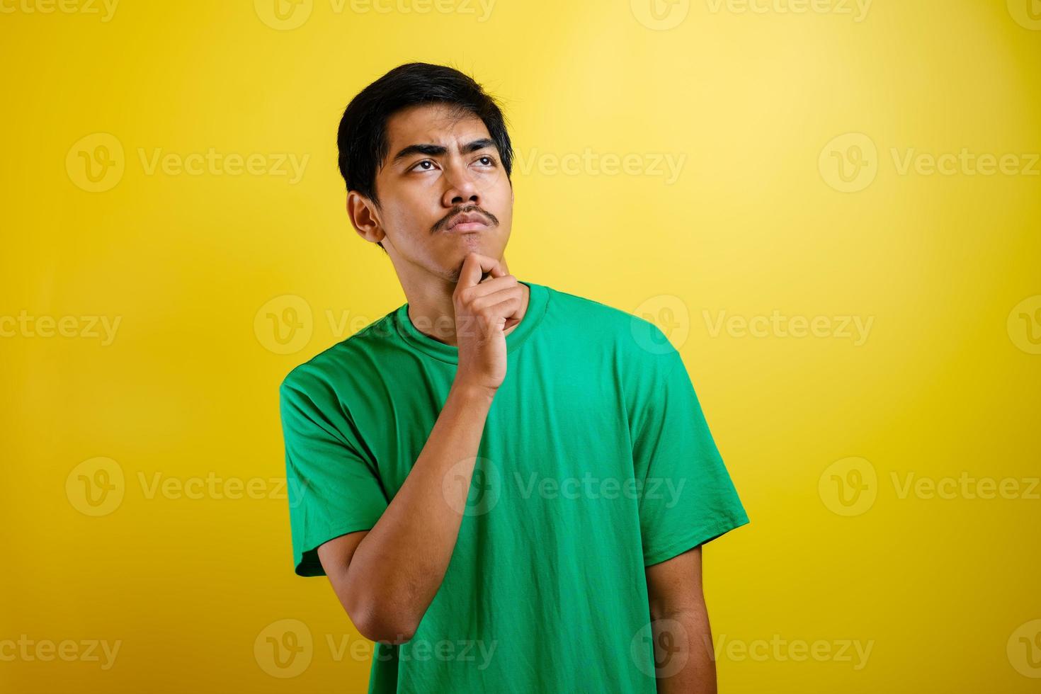 Asian man in green t-shirt thinking something, looking for good idea photo
