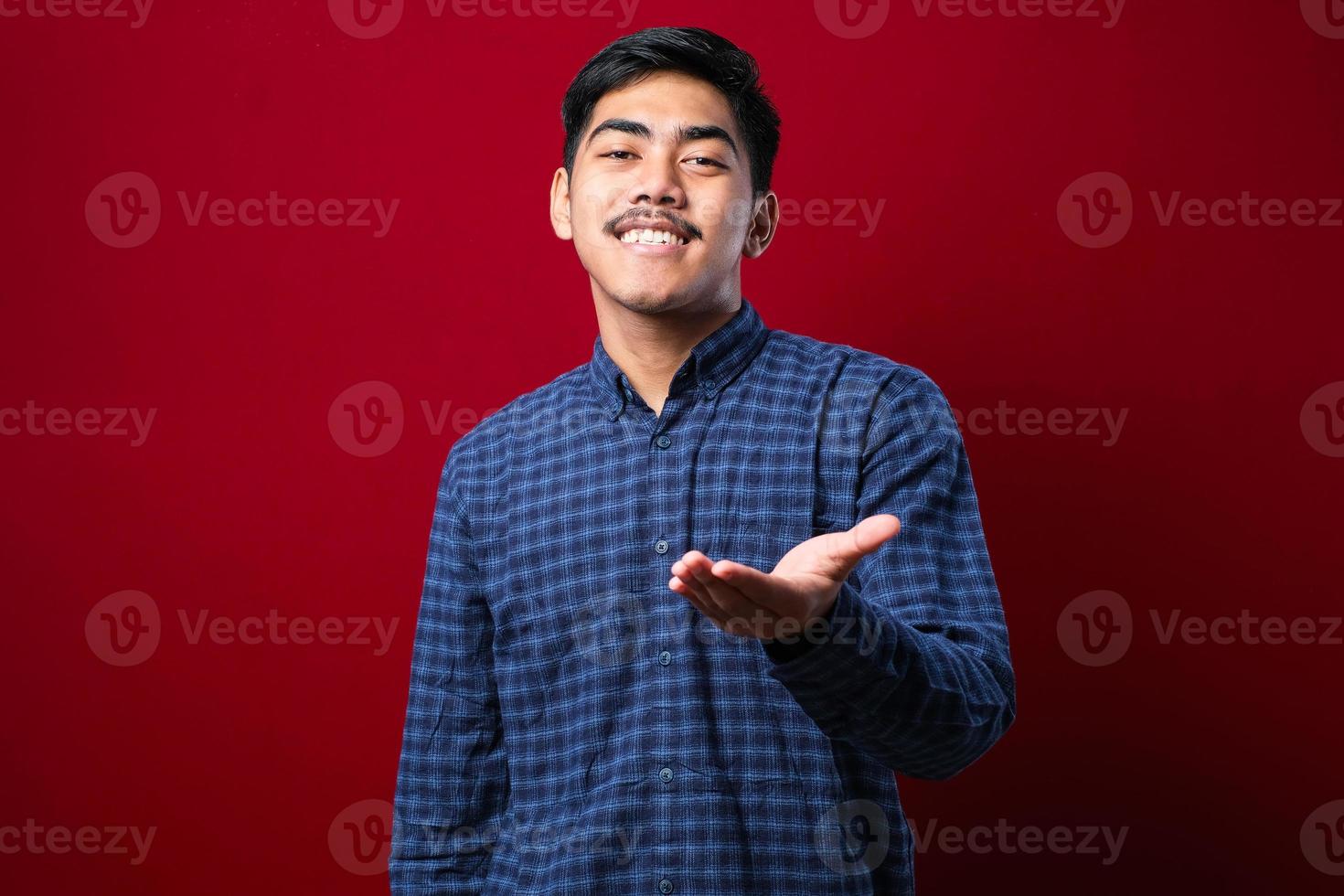 Asian young man wearing casual clothes smiling friendly offering handshake as greeting and welcoming. successful business. photo