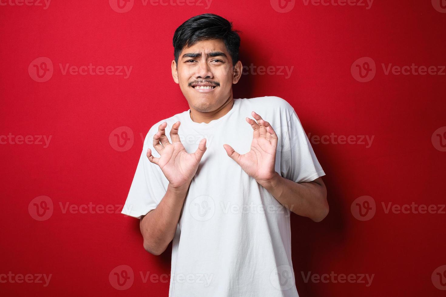 Young handsome asian man wearing white t-shirt standing moving away hands palms showing refusal and denial with afraid and disgusting expression. Stop and forbidden. photo