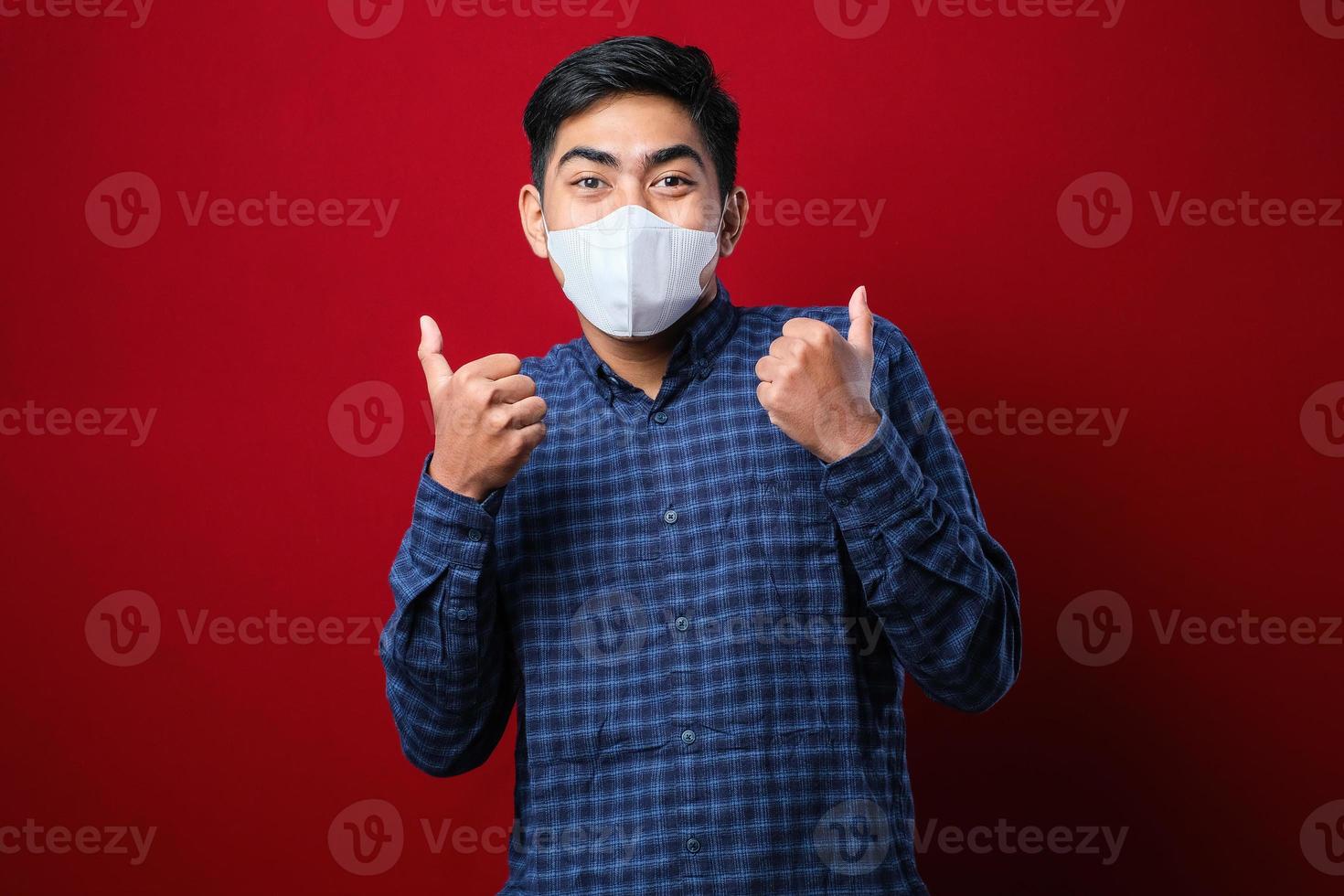 Asian college student man thumb up and wearing masks to prevent the spread of Corona virus while back to school. photo