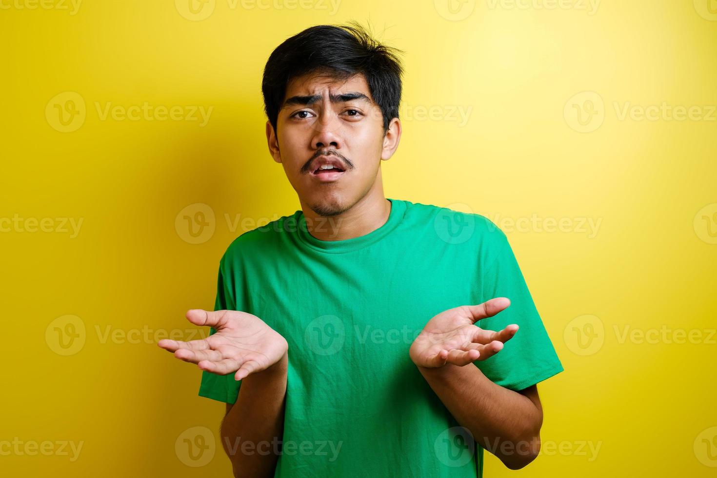 Portrait of confused annoyed man shrug raising arms, asking and having no idea what happening photo