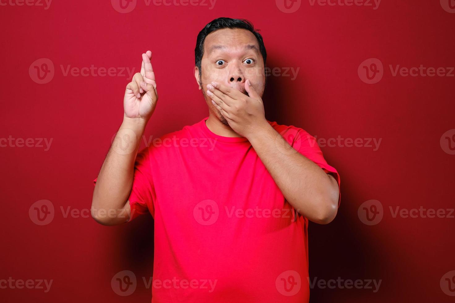 Asian man close his mouth and cross fingers, making promise gesture photo