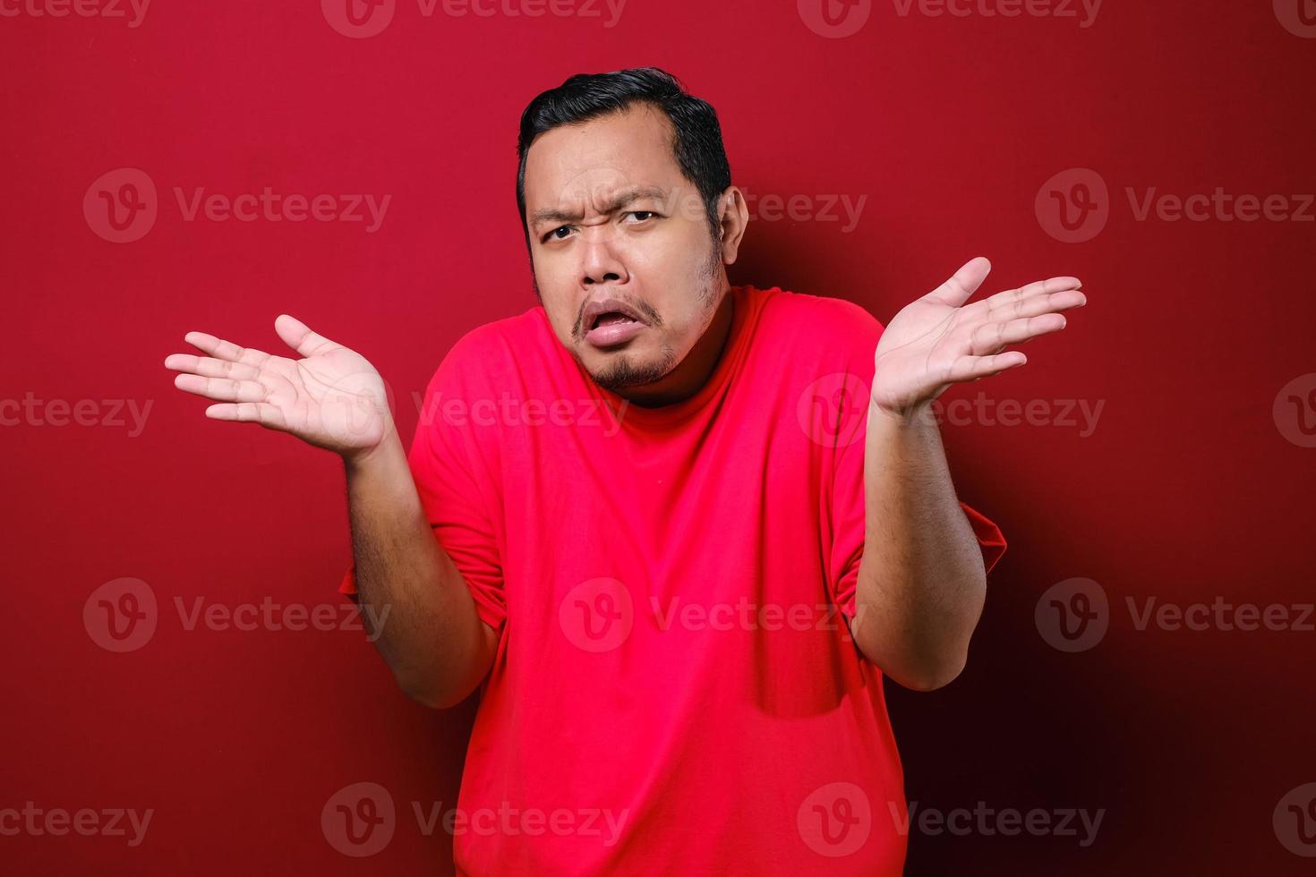 Portrait of confused annoyed man shrug raising arms, asking and having no idea what happening photo