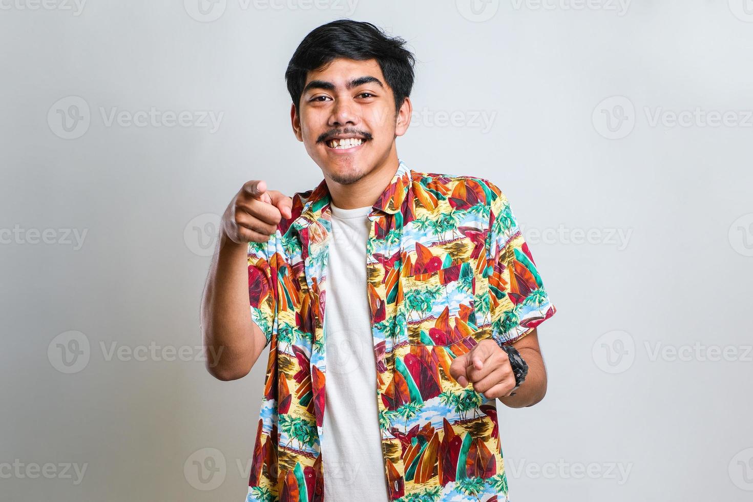 Asian man pointing to you and the camera with fingers, smiling positive and cheerful photo