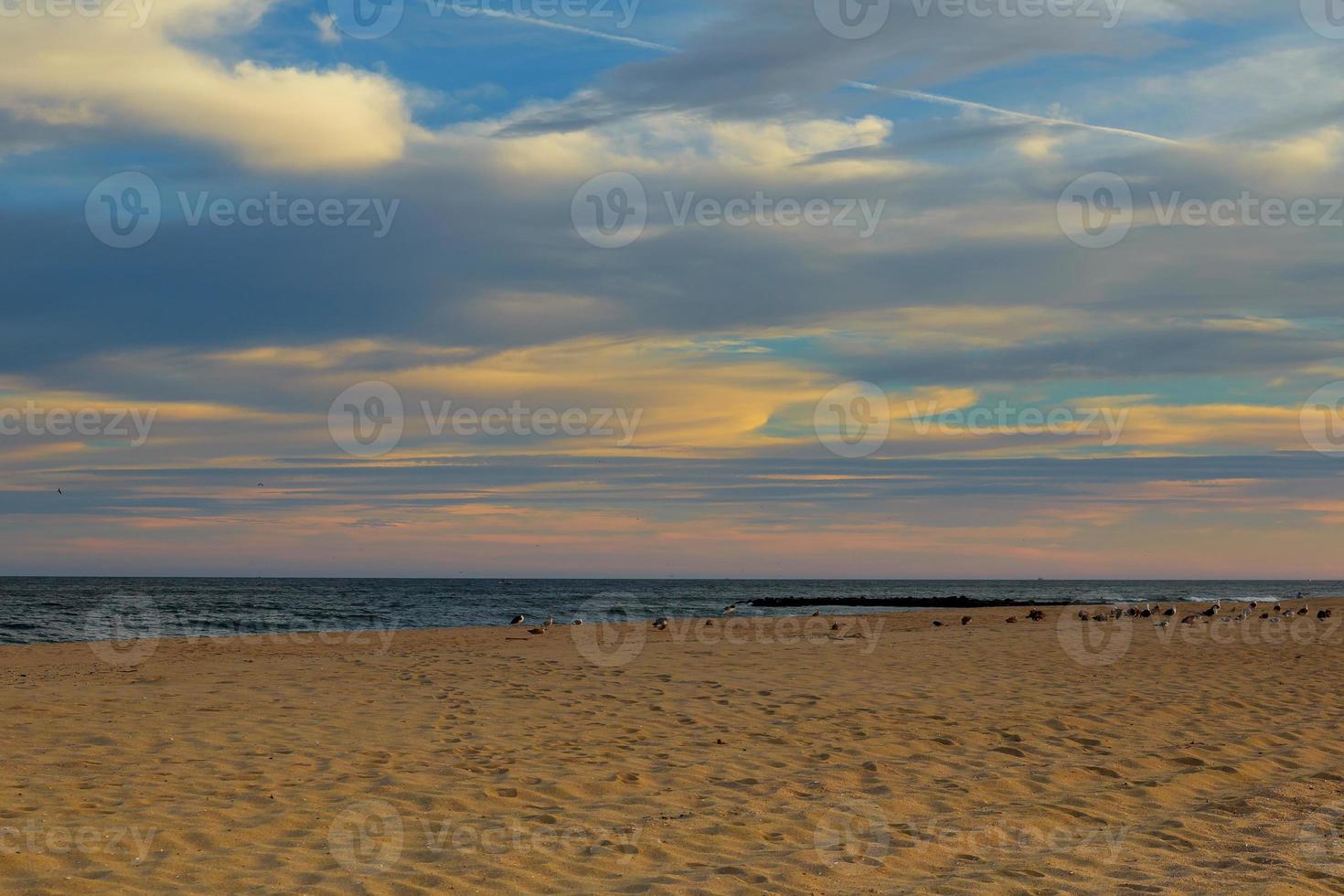 Magic sunset view seascape with beautiful colorful sky, sun and clouds. Smooth sand on the beach white foam of ocean. Karon Phuket Thailand. photo