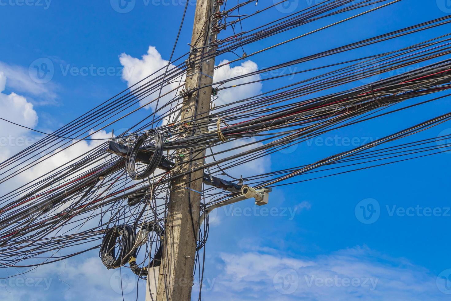 caos absoluto del cable en el poste de energía tailandés cielo azul de tailandia. foto