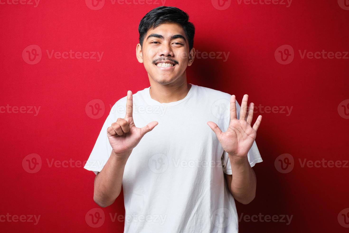 Handsome young man wearing casual clothes showing and pointing up with fingers number seven while smiling confident and happy photo