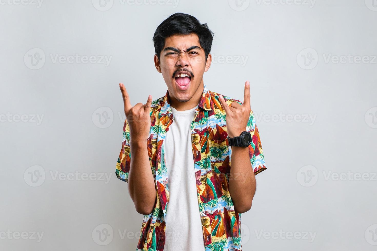 Handsome man with mustache shouting with crazy expression doing rock symbol with hands up. photo