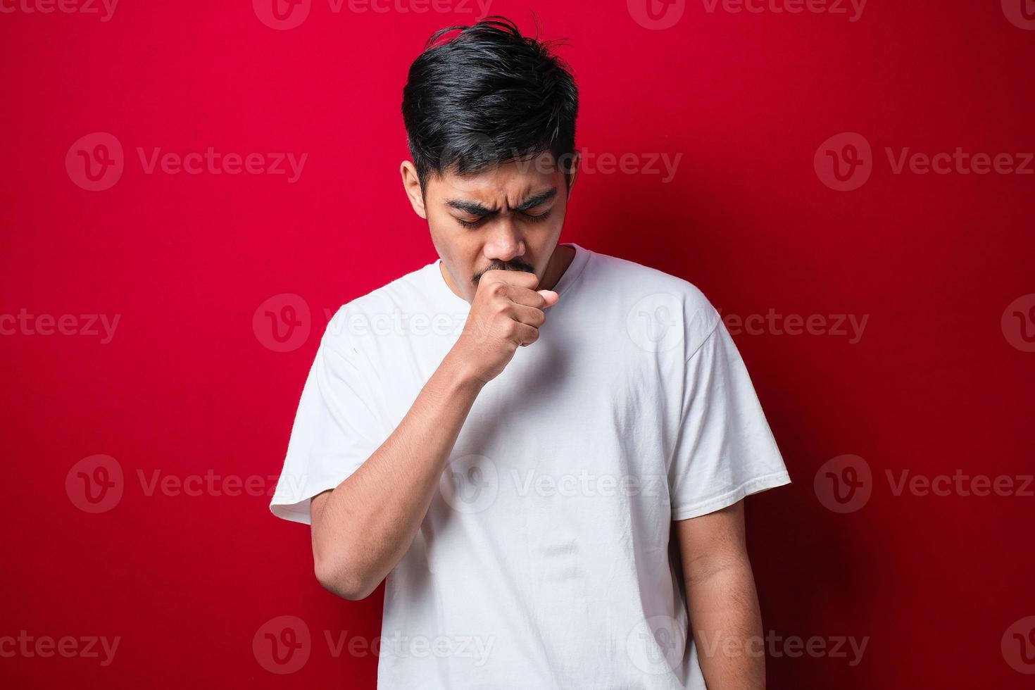 joven asiático tosiendo con dolor de garganta, concepto de hombre con alergia foto