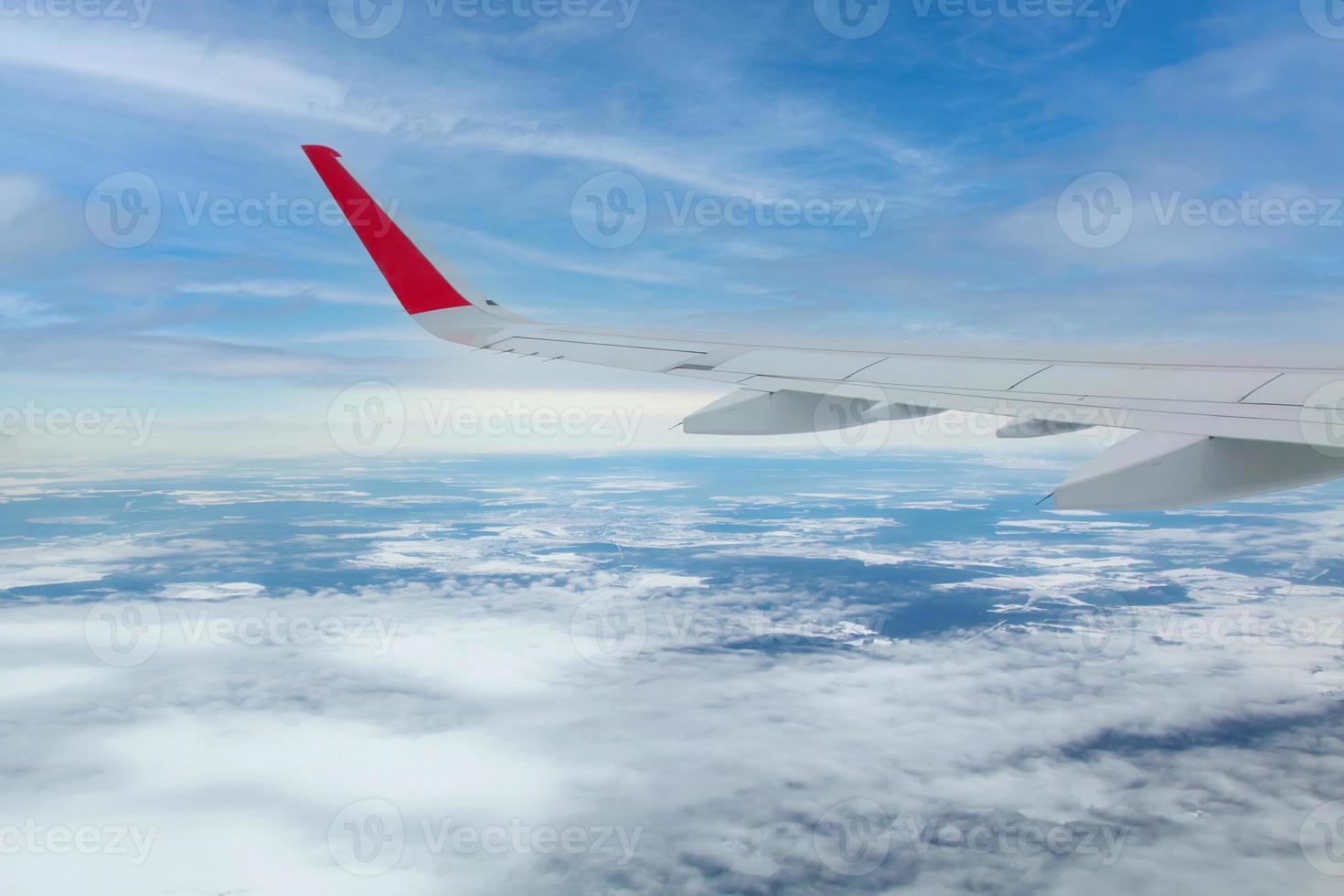 airplane wing flying above the clouds photo