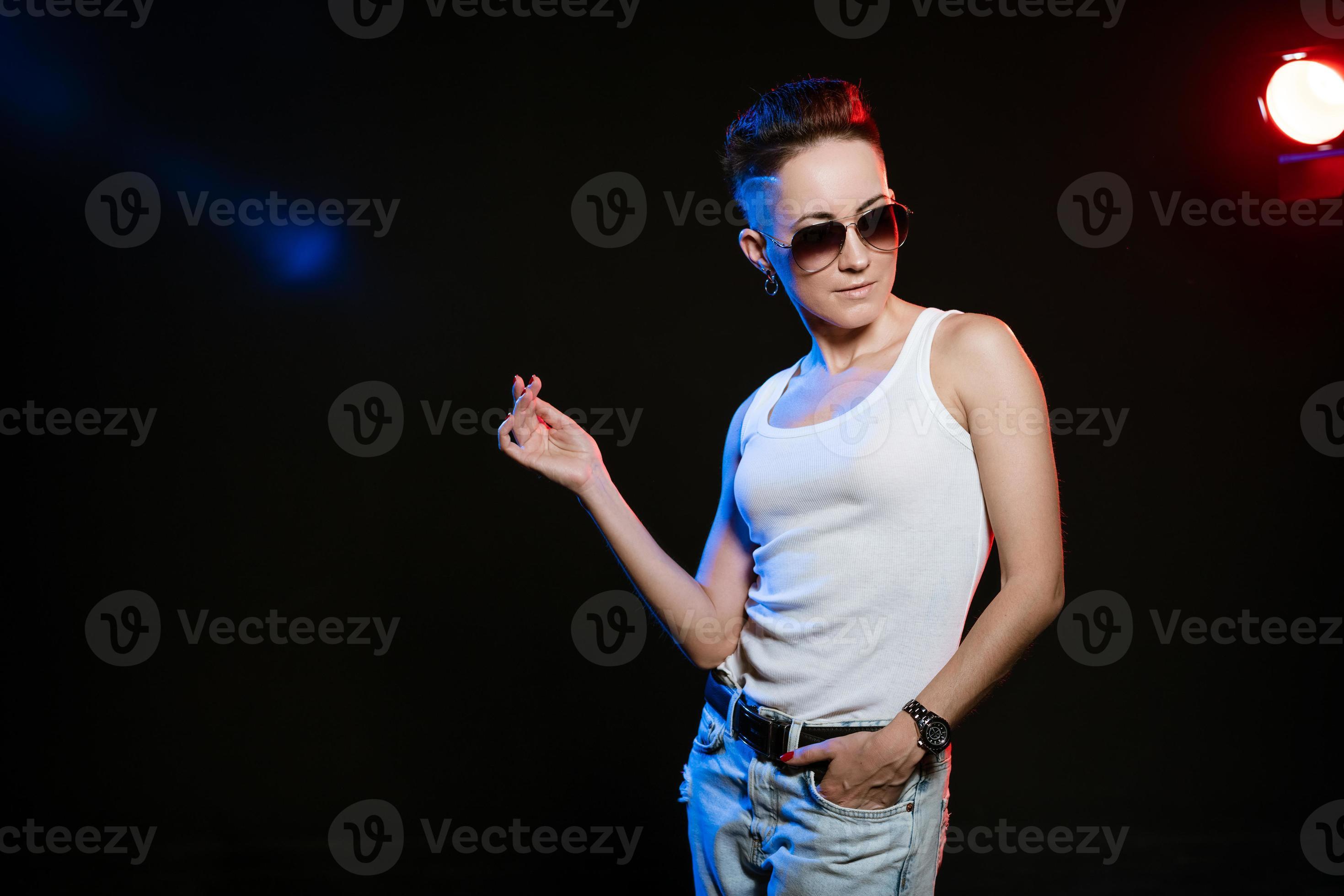 Fashionable woman on style posing in studio on black background. Short