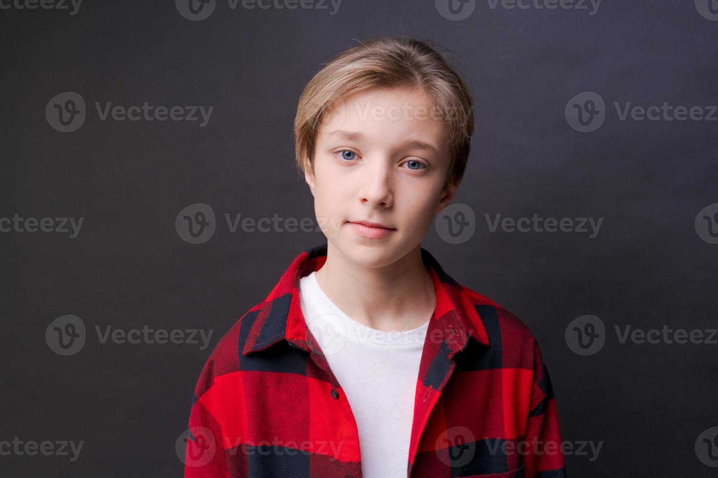 Close-up headshot of confident concentrated young man in plaid shirt looking photo