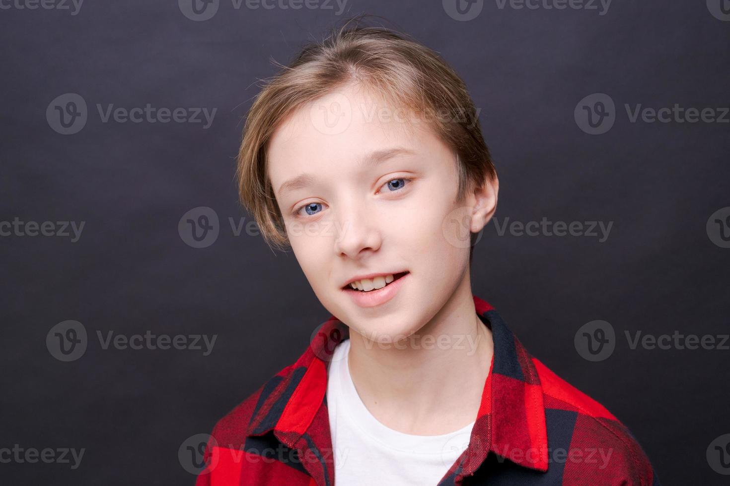 Close-up young smiling man in casual clothes in a red checkered shirt, posing photo