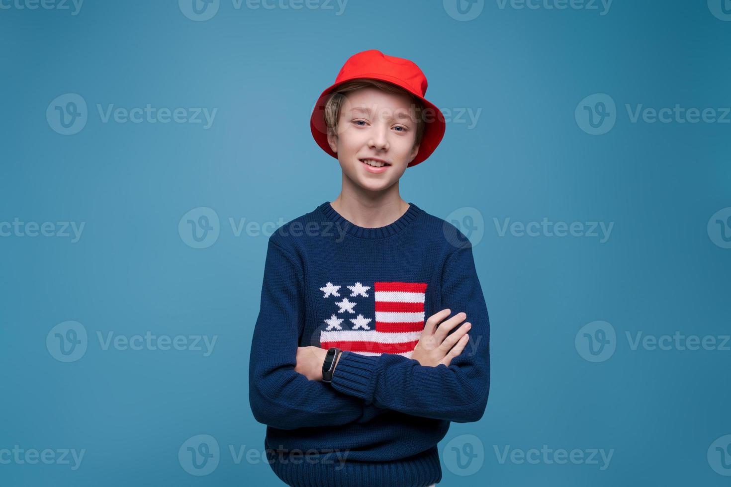 Confident caucasian young guy in casual wear with crossed arms isolated on blue photo