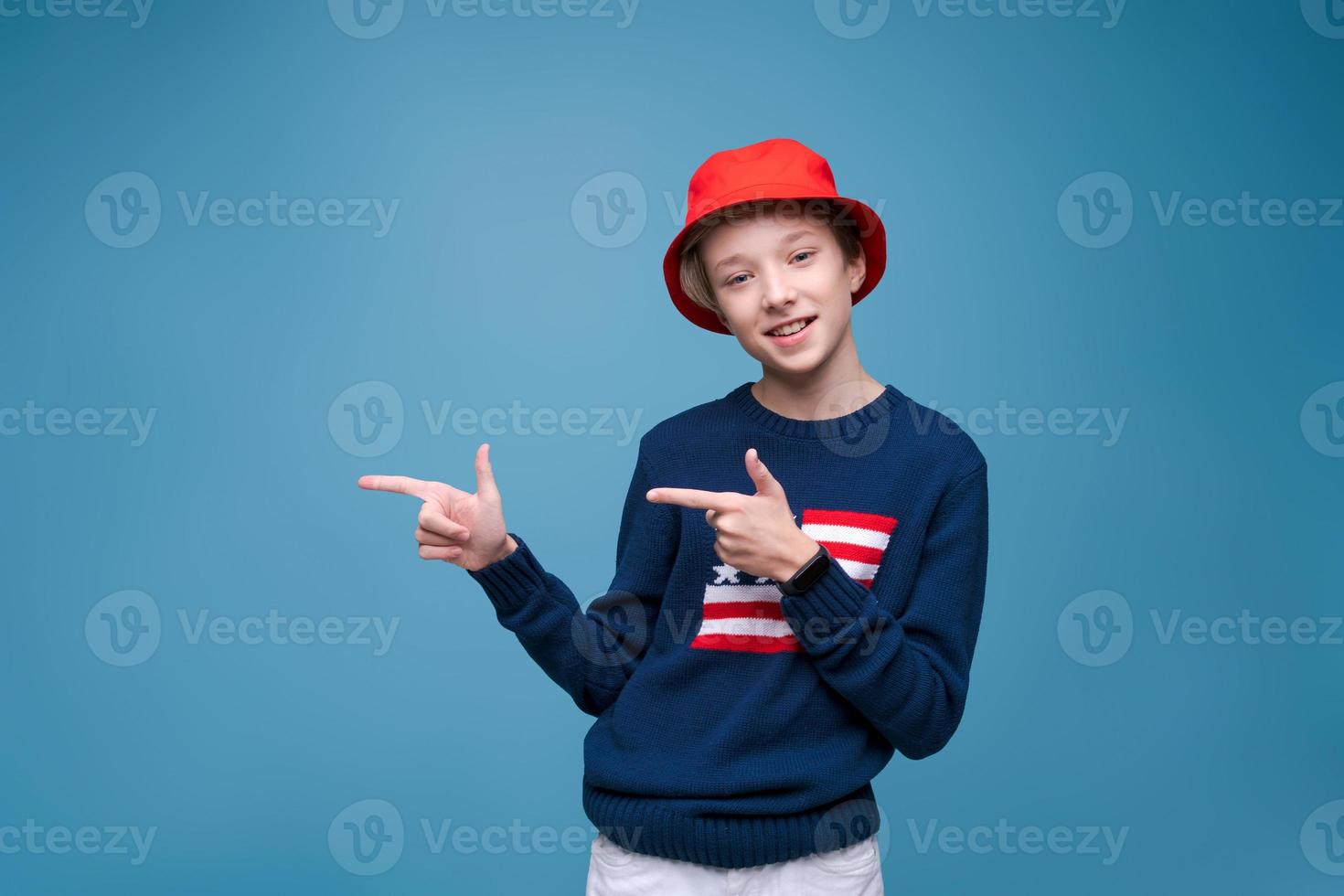 Smiling cheerful young guy in red panama hat and blue sweater with us flag photo